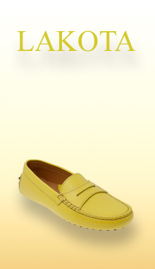 Ein eleganter, gelber Mokassin von uns ist vor einem sanften, warmen Farbverlauf im Hintergrund platziert, der an Fr&uuml;hlings- oder Sommert&ouml;ne erinnert. Der Schuh wirkt leicht und bequem, mit einer schlichten Silhouette, feinen N&auml;hten und einer flexiblen Sohle, die f&uuml;r entspannten Tragekomfort steht.