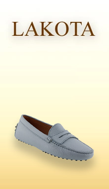 Ein eleganter, hellblauer Mokassin von uns ist vor einem sanften, warmen Farbverlauf im Hintergrund platziert, der an Fr&uuml;hlings- oder Sommert&ouml;ne erinnert. Der Schuh wirkt leicht und bequem, mit einer schlichten Silhouette, feinen N&auml;hten und einer flexiblen Sohle, die f&uuml;r entspannten Tragekomfort steht.